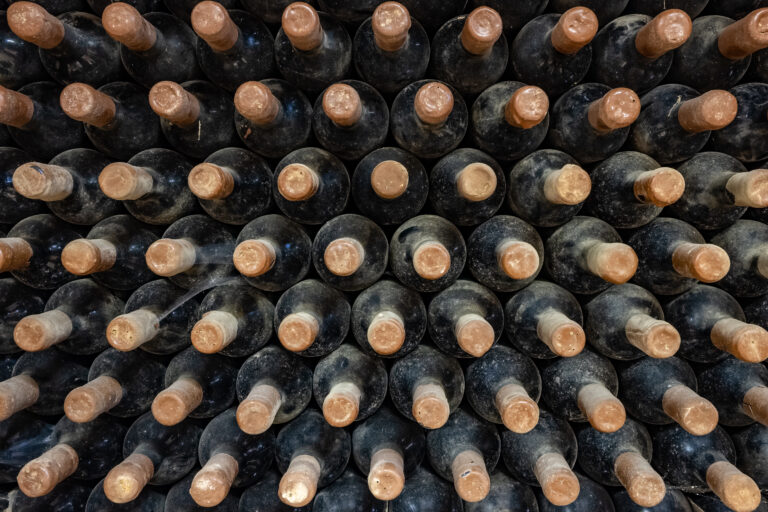 Wine bottles stacked up in old wine cellar