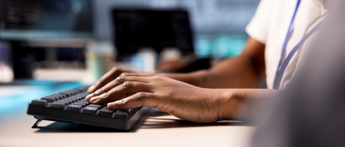 Close up of cybersecurity expert monitoring security incidents affecting server hub network. Programmer in data center typing on keyboard, protecting company critical infrastructure from cyber threats